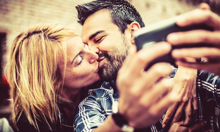 couple kissingwhile taking selfie