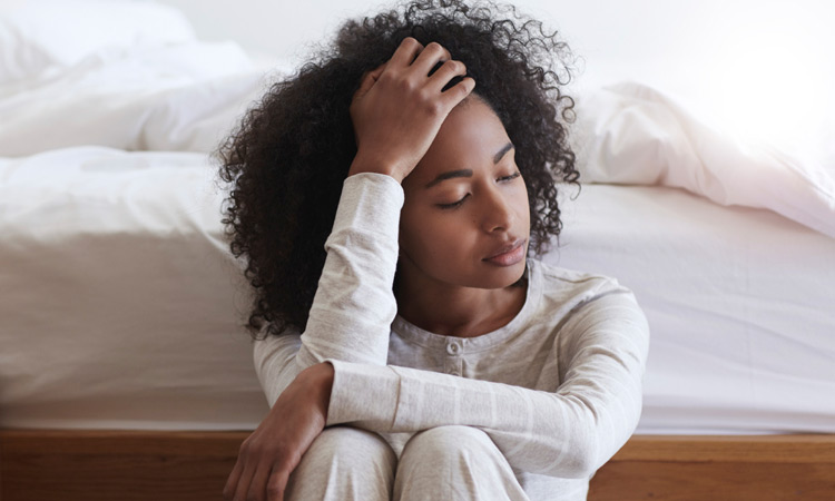 woman holding head from losing sleep