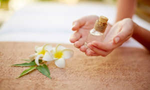 holding a glass vial of essential oil